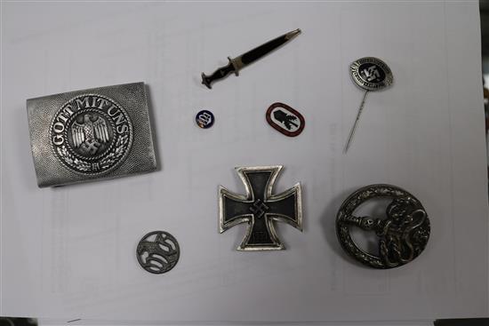 A German Iron Cross 1st class, an SS lapel badge number 792, dagger lapel pin, German army belt buckle, three German badges without pin